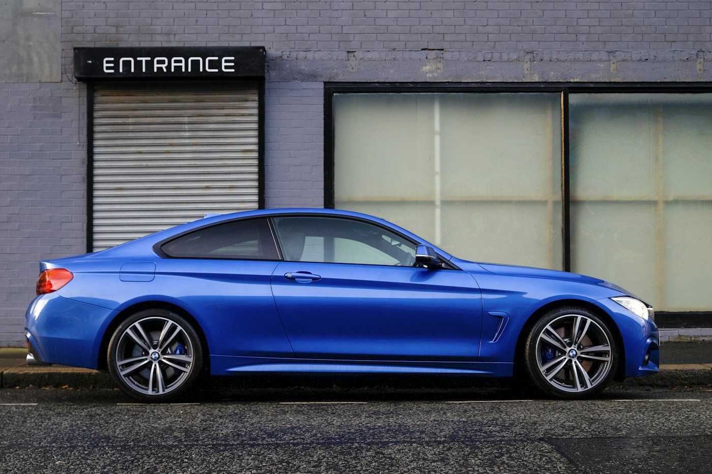 A clean blue coupe after a wash