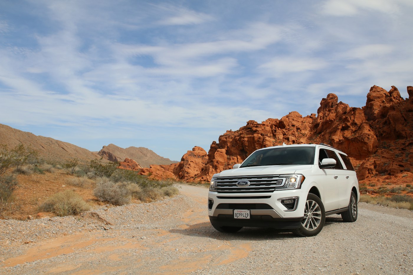 A white SUV on a dusty road
